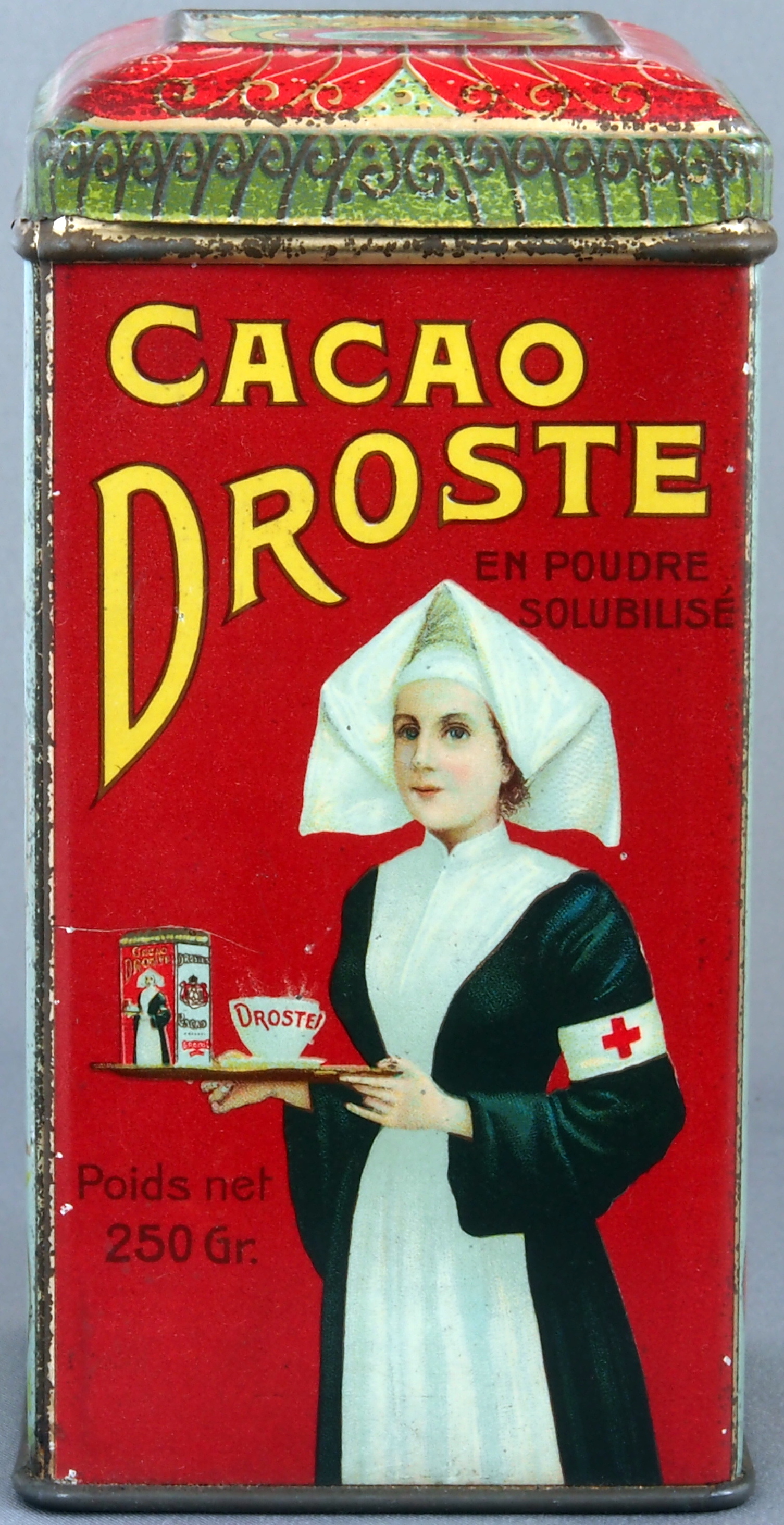 Vintage red Droste cocoa tin featuring a nurse holding a tray with another Droste tin.