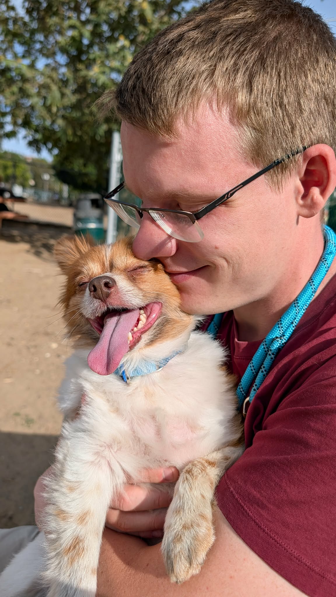 Michael holding Teddy, who has his eyes closed and tongue out.